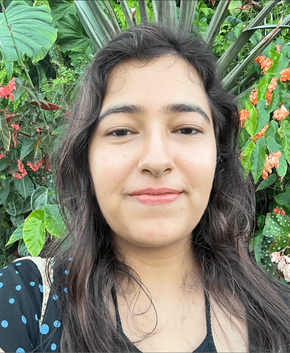 Akansha smiling in front of tropical plants